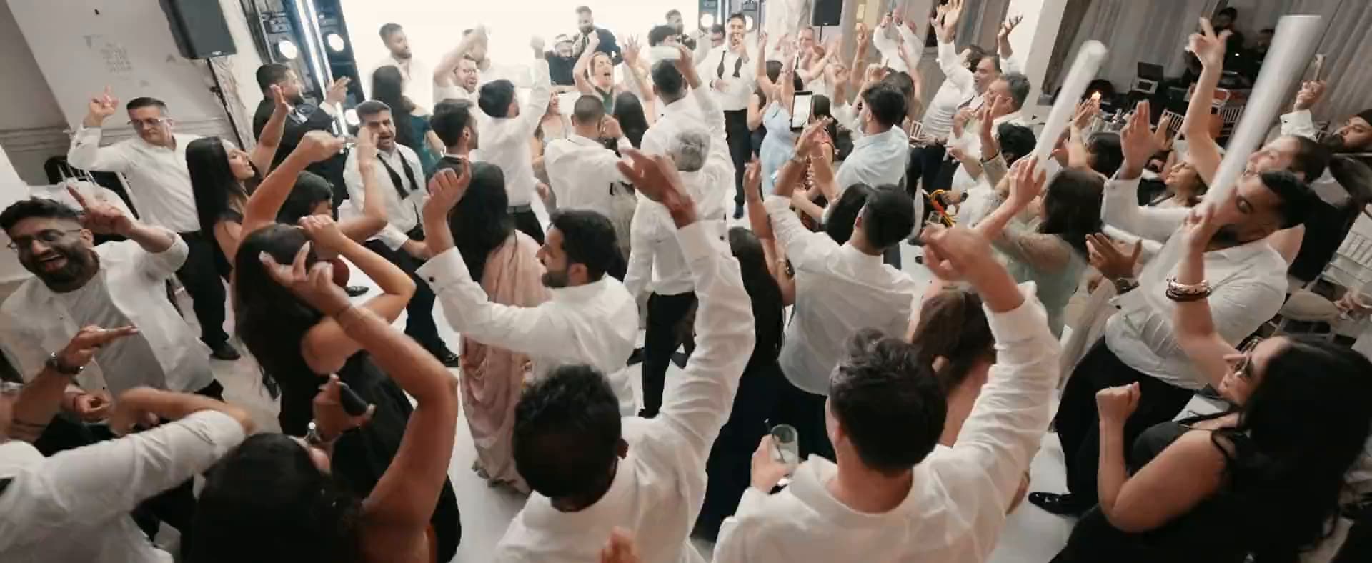 Wedding guests dancing with their hands in the air