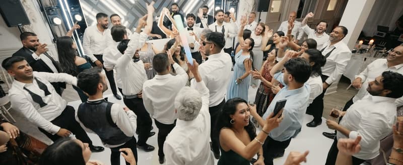 Wedding guests dancing together in front of Prit Nasha's booth