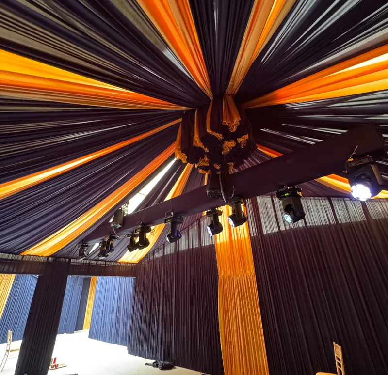 Marquee ceiling with draping and warm light, moving heads rigged before guests arrive